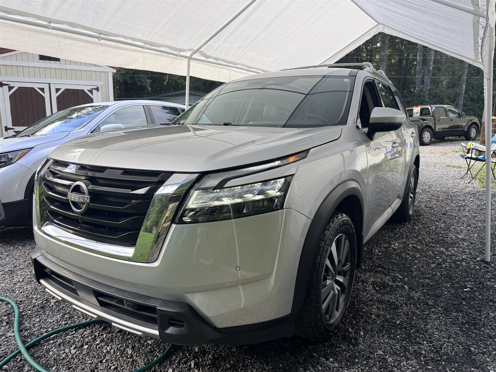 Detailed light-colored Nissan SUV under a canopy